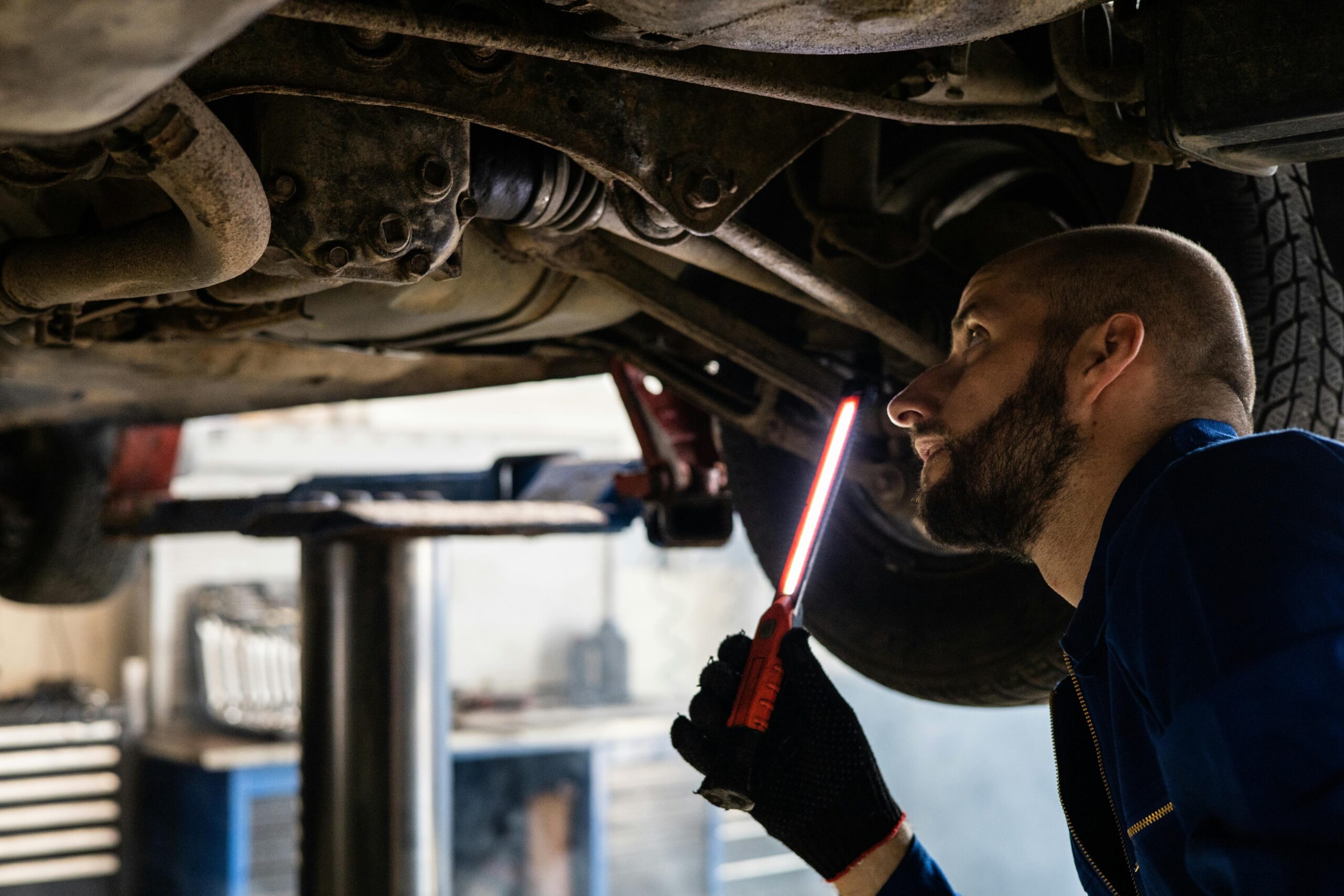 Professional mechanic performing used car inspection